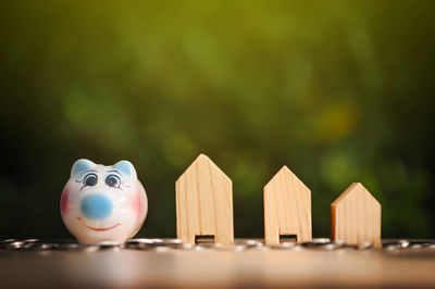 Piggy bank and coins by model house on table