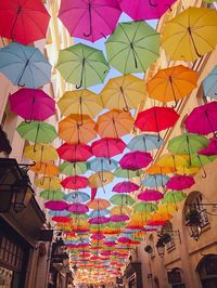 Low angle view of multi colored umbrellas hanging at market