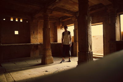 Rear view of man walking in corridor of building