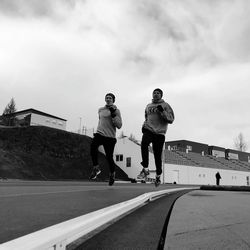 Rear view of man skateboarding on skateboard against sky