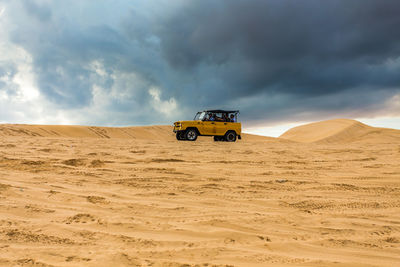 Tractor in desert against sky