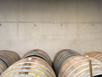 Barrels by wall in wine cellar