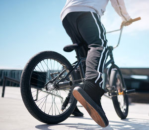 Low section of man riding bicycle on street