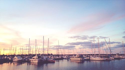 Boats in calm sea at sunset