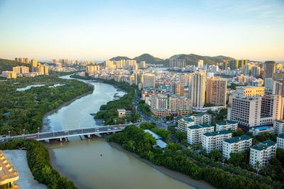 High angle view of river amidst buildings in city against sky