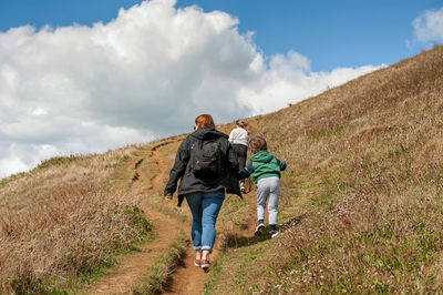 Family enjoying walking at the top of jurassic cliffs. west bay dorset coast. england.