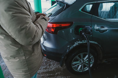 Midsection of man holding car