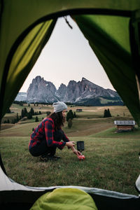 Side view of woman on field seen through tent