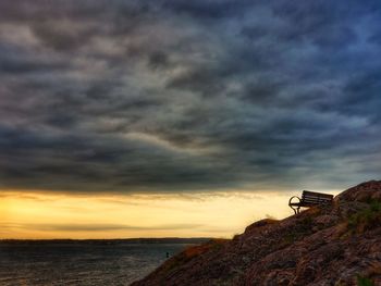 Scenic view of sea against dramatic sky during sunset