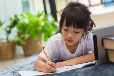 Girl painting while learning over digital tablet at home