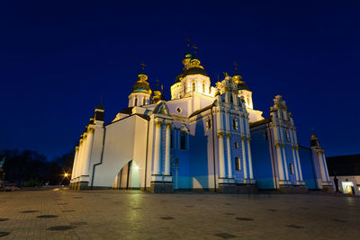 Low angle view of illuminated building against clear blue sky