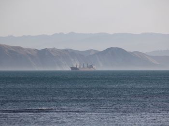 Scenic view of sea and mountains against sky