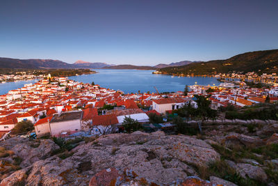 Townscape by sea against clear blue sky