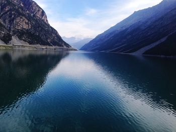 Scenic view of lake by mountains against sky