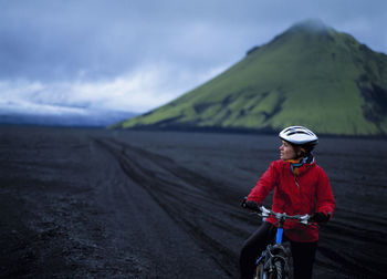 Woman riding her bike on maelifellssandur in the icelandic highlands