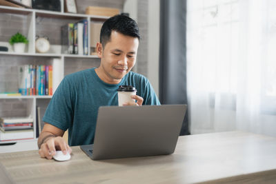 Businesswoman using laptop at table