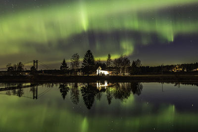 Reflection of trees in lake against sky at night