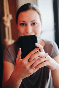 Portrait of young woman using mobile phone