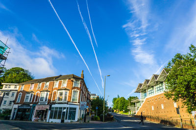 View of buildings with shops by road in city