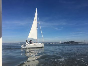 Sailboat sailing on sea against blue sky