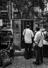 Rear view of people walking on street in city