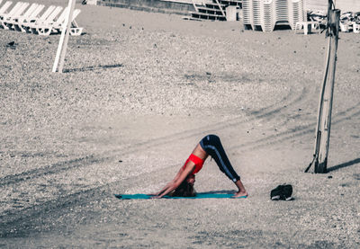 Close-up of woman practising yoga on beach