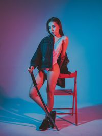 Full length of young woman sitting on seat
