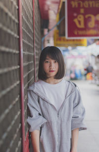 Portrait of woman standing by shutter 