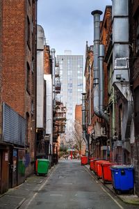 Road amidst buildings in city against sky