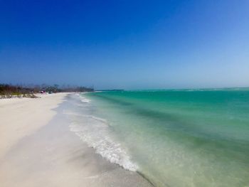 Scenic view of beach against clear blue sky