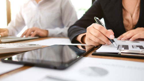Midsection of man using laptop on table