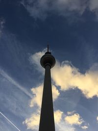 Low angle view of fernsehturm against cloudy sky