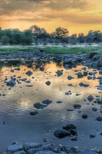 Scenic view of lake against sky at sunset