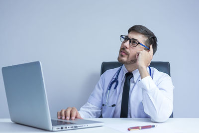 Man using mobile phone while sitting on table