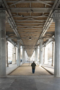 Rear view of man walking on railroad station