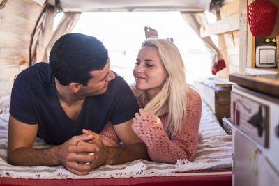 Romantic young couple relaxing in vintage van