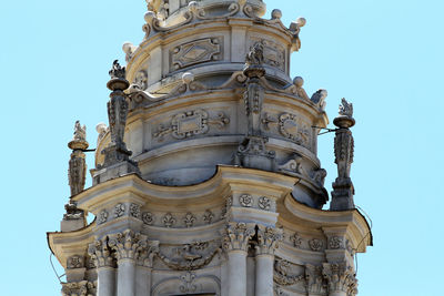 Monolithic spiral spire of the church of alla sapienza in rome. white decorated marbles. blue sky.