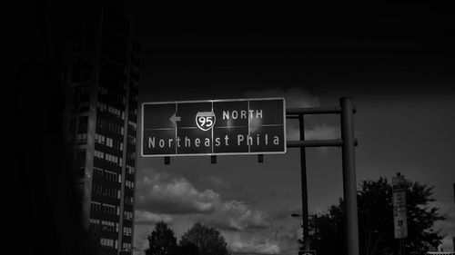 Low angle view of road sign against sky