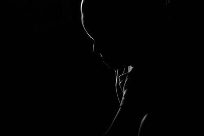 Close-up of silhouette man against black background