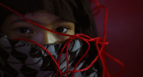 Close-up of man with red christmas lights