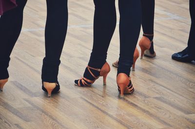 Low section of people standing on hardwood floor