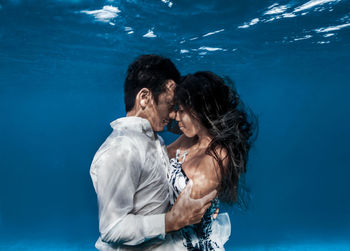 Couple kissing against sea