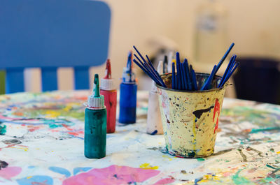 Paint brushes and water colors on messy table