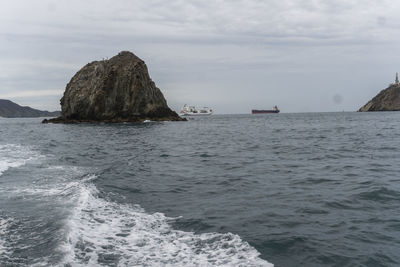 Scenic view of rocks in sea against sky