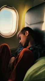 Boy sleeping while traveling in airplane