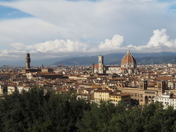 View of cityscape against cloudy sky