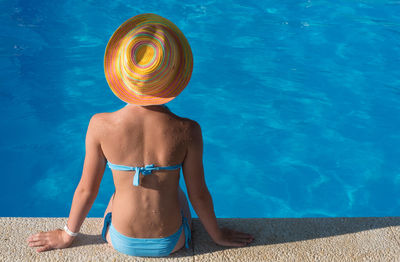 Full length rear view of shirtless man in swimming pool
