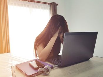 Tired woman using laptop at desk