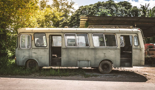 Abandoned vintage van against trees