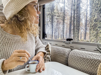 Side view of woman using mobile phone while sitting at home